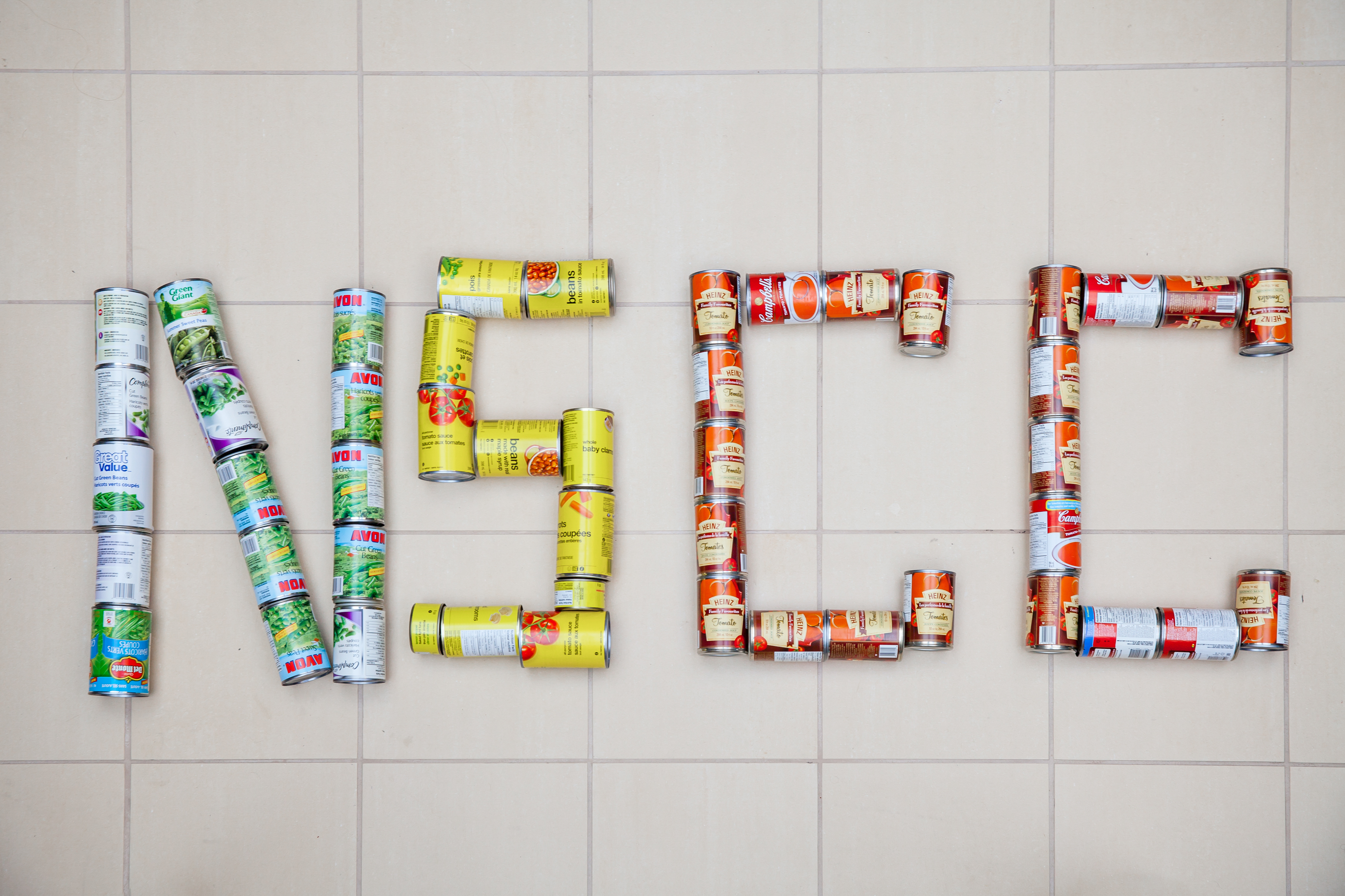 NSCC spelled out on a tile floor with canned goods